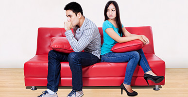 Couple on couch with angry faces