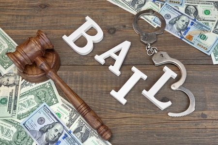 Image of money and handcuffs and gavel with word bail