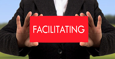 Person holding card that says Facilitating