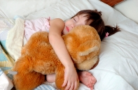 Image of child sleeping with a teddy bear