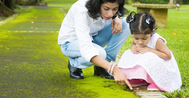 Mother and young daughter looking at something on the ground