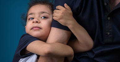 Child hugging parent's arm