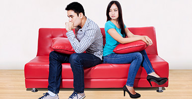 Couple sitting next to each other facing away from each other