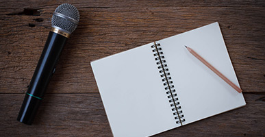 microphone and notebook laying on a table