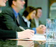 Committee members at a table with notebooks and cups of water