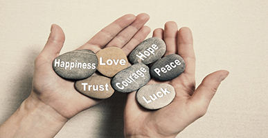 Hand holding inspirational rocks with words
