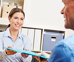 Female handing a file to a man