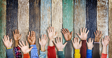 diverse kids raising hands