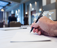 Hand writing on paper at a conference